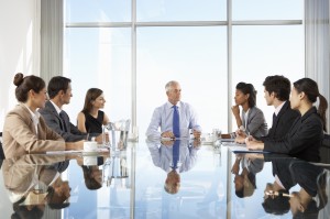 Group Of Business People Having Board Meeting Around Glass Table